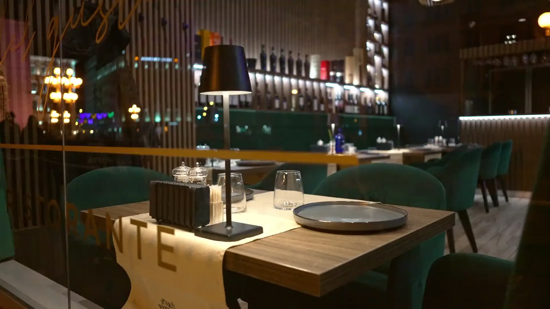 Sala di un ristorante la sera, luci calde e insegna al neon